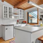 Kitchen with countertop, sink, refrigerator, and window.
