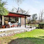 House with terrace, garden and seating. View of surrounding trees.