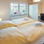 Double bed with linens, desk, wardrobe, and window with view.