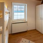 Room with bunk bed, window, and wardrobe