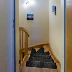 Wooden staircase with carpet and wall pictures