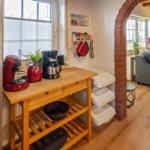 Kitchen area with countertop, coffee maker, and view of living room.