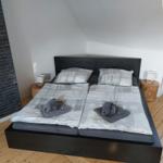 Schlafzimmer mit Doppelbett, zwei Nachttischen und Holzboden.