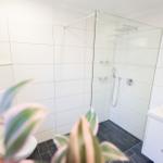 Modernes Badezimmer der Ferienwohnung Bergmoment in Blankenburg Harz mit geräumiger ebenerdiger Dusche.