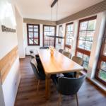 Heller Essbereich im Wintergarten der Ferienwohnung Bergmoment in Blankenburg Harz mit grossem Tisch fuer 8 Personen.