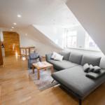 Modernes Wohnzimmer der Ferienwohnung Bergmoment in Blankenburg Harz mit Sofa, Dachschraege und offenem Wohnkonzept.