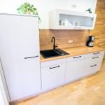 Moderne Kueche der Ferienwohnung Bergmoment in Blankenburg Harz mit Induktionskochfeld, Backofen, Geschirrspueler und Mikrowelle.