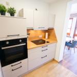 Moderne Kueche der Ferienwohnung Bergmoment in Blankenburg Harz mit Induktionskochfeld, Backofen, Geschirrspueler und Mikrowelle.