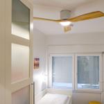 Schlafzimmer mit Bett, Fenster und Deckenventilator.
