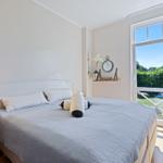 Schlafzimmer mit Bett, Fenster und Holzboden.