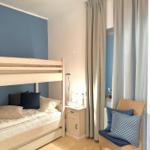 Ein Schlafzimmer mit Doppelstockbett, Nachttisch und Stuhl mit Kissen.