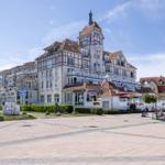 Großes Hotel mit Balkonen und Terrassen an sonnigem Tag.