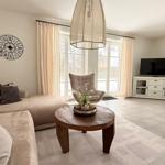 Wohnzimmer mit Sofa, TV und Glastüren zum Garten.