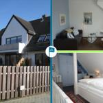 Ferienhaus mit Wohnzimmer und Schlafzimmer. Außenansicht mit Holzzaun.