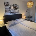 Schlafzimmer mit Doppelbett, Wandbildern und Nachttischen.