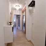 Flur mit Holzboden, Spiegel und Modellboot auf Schrank.