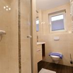 Badezimmer mit Dusche, Toilette und Waschbecken.