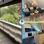 Terrasse mit Blick auf Wald, Wohnzimmer mit Sofa und Küche mit Arbeitsplatte.