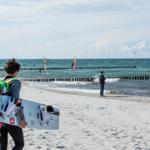 Windsurfer bereiten sich am Strand auf das Segeln vor.