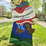 Holzschild mit Walpurgisnacht-Veranstaltungsinformation am Kurhaus.