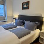 Schlafzimmer mit Bett, zwei Nachttischen und Bild an der Wand.