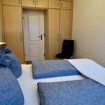 Schlafzimmer mit Doppelbett, Kleiderschrank und Stuhl.