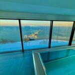 Pool mit Blick auf schneebedeckten See und Pier