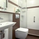 Badezimmer mit Dusche, Toilette und Waschbecken mit Spiegel.