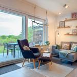 Wohnzimmer mit Sofa, Sessel und Terrasse mit Tisch und Stühlen.