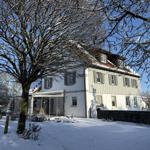 Haus mit Schneebedecktem Grundstück und großen Fenstern