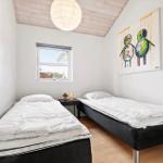 Two single beds, window, wall art, and ceiling lamp in a bedroom.