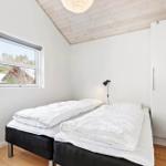 Room with double bed, window, and wardrobe. Wooden ceiling and floor.