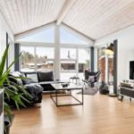 Living room with large windows, sofa, coffee table, and TV.