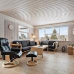 Living room with sofa, armchair, and TV mounted on the wall.