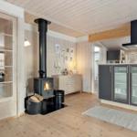 Kitchen with wooden floor and wood-burning stove. Entrance to the bedroom area.