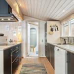 Kitchen with countertops, sink, stove, and dishwasher. Passage to the shower.