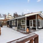 Modern villa with snow-covered yard and large glass area