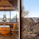 Dining area with wooden table and chairs. View of rural surroundings through windows.