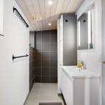 Bathroom with shower, sink, and lit mirror