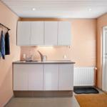 Kitchen area with white cabinets, sink, and window to the outside.