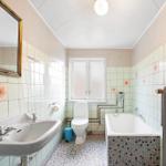 Bathroom with sink, toilet, bathtub, and mirror on the wall.