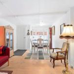 Living and dining area with red sofa, dining table, and floor lamp.