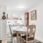 Dining room with round table, chairs, and tall wall clock