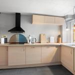 Kitchen with wooden cabinets, range hood, and window to outside.