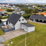 Modernes Ferienhaus mit Terrasse und Garten. Blick auf Strand und Küstenlandschaft.