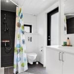 Bathroom with shower, toilet, and sink. Shower curtain with pattern.