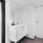 Bathroom with sink, mirror, and door.