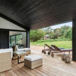 Deck with seating, lounge chairs, and view of green field.