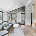Living room with sofa, fireplace, and large windows for outdoor view.