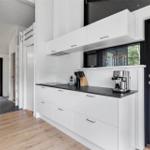 Kitchen with white cabinets, black countertop, and view of terrace